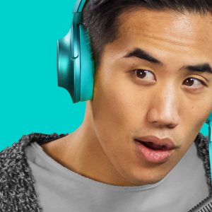 Andrew Huang wearing teal headphones with a raised eyebrow