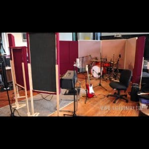 Recording studio live room with acoustic panels, a drum kit and an electric guitar